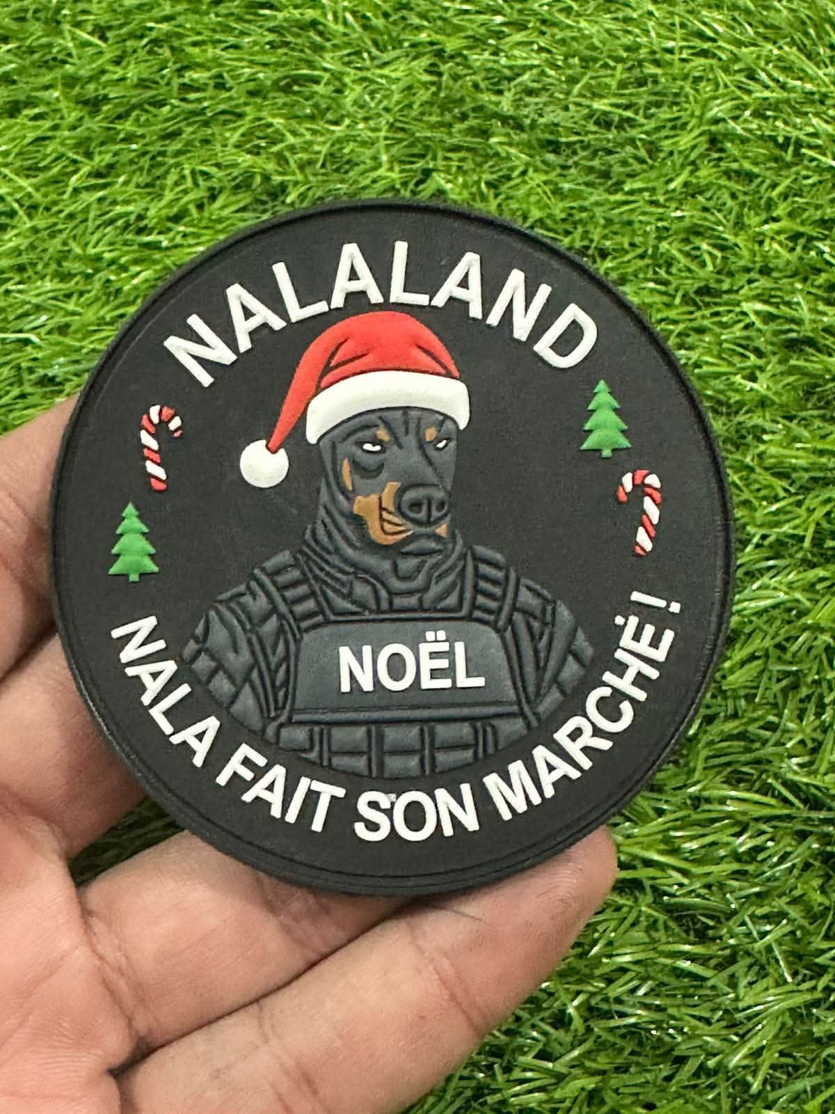 Black round Malaland Christmas PVC morale patch featuring a tactical dog wearing a Santa hat with festive candy canes, trees, and French text on a durable 3D rubber design. Custom PVC Morale Patch